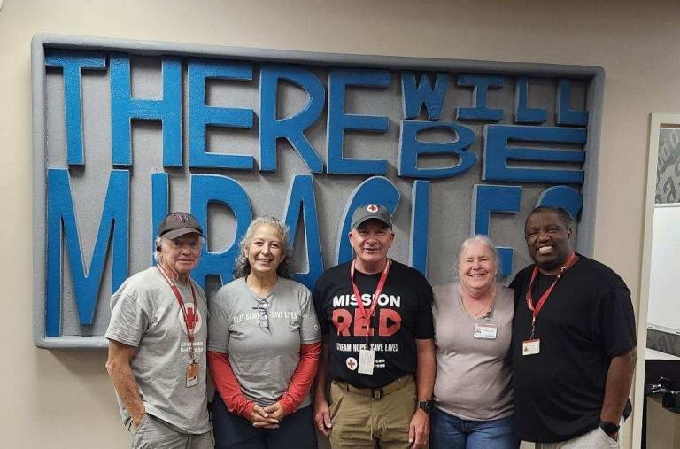 group of people, some wearing Red Cross badges, stand together