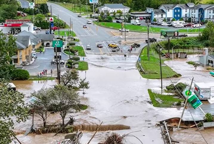 A flooded intersection, stranded cars and damaged structures.