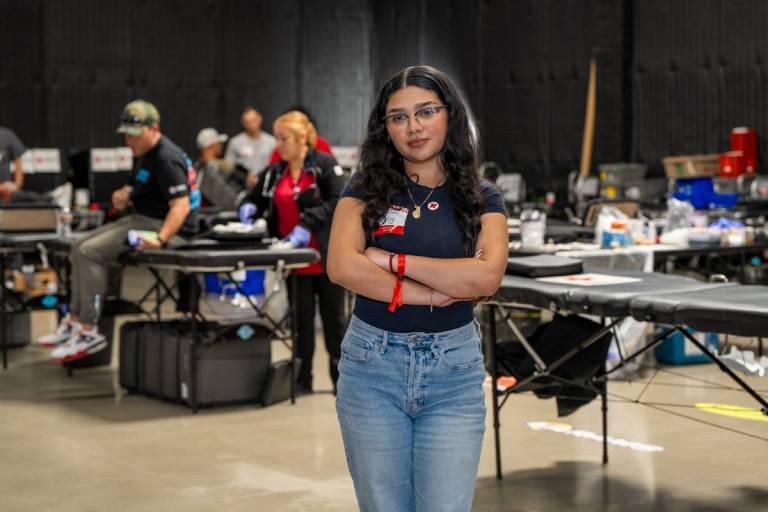 two women sit at a table wearing Red Cross stickers