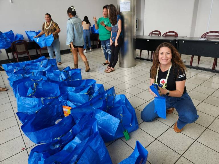 several people fill blue bags with groceries
