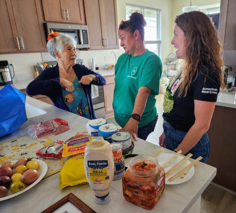 Several people stand inside a kitchen