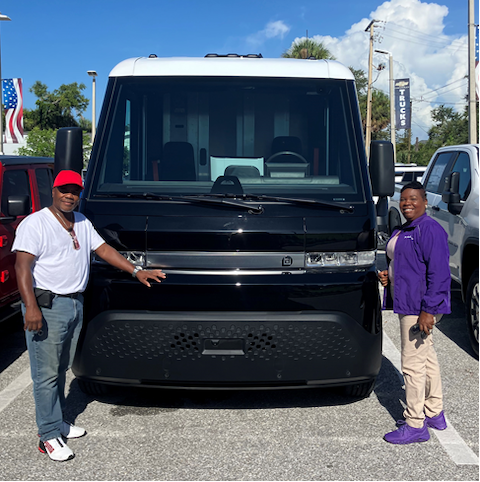 A man and a women stand in front of a donated van.