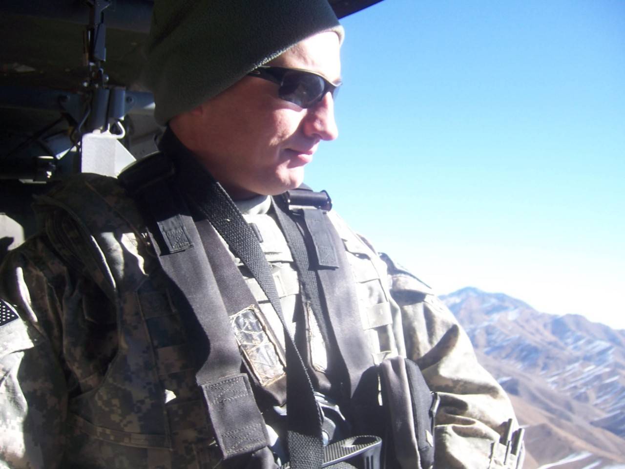 Kyle surveys the mountains above Zabul, Afghanistan from out the side of a helicopter.|