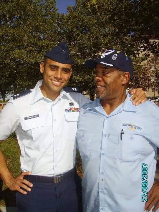 A young Shaun in formal military dress uniform takes a photo with his arm around his father who wears a hat with U.S. Air Force insignia. 