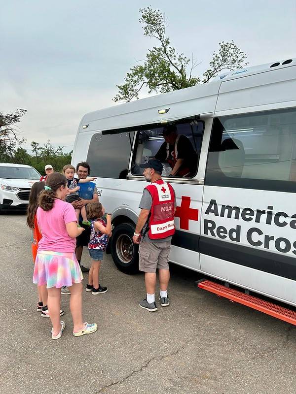 people line up at Red Cross vehicle to receive meals