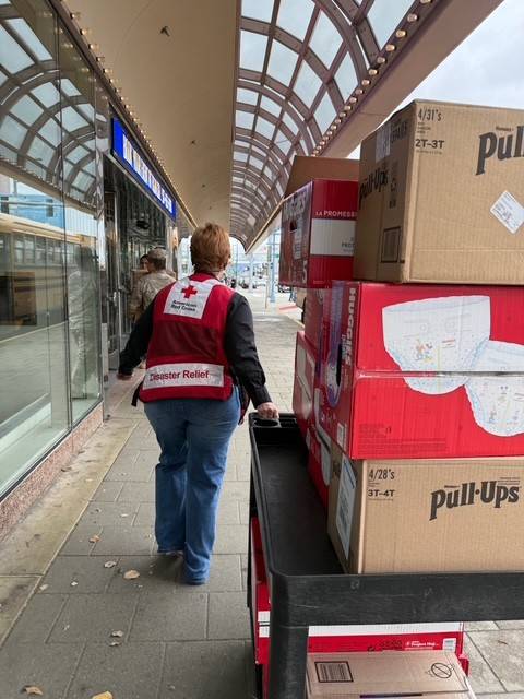 woman helps unload relief supplies at a Red Cross shelter