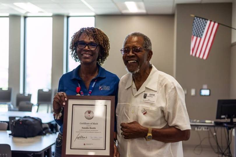 Natalie Bostic is holding her Certificate of Merit Lifesaving Award for saving her neighbor’s life.