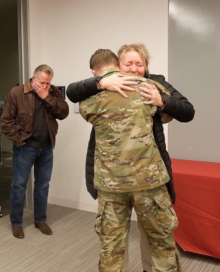 Pfc. Patrick Konczal hugs his mother, Trish, during their recent surprise reunion in Fairfax, Virginia. The American Red Cross and United Airlines joined forces to bring Konczal home from South Korea to see his family for the first time in 18 months.
