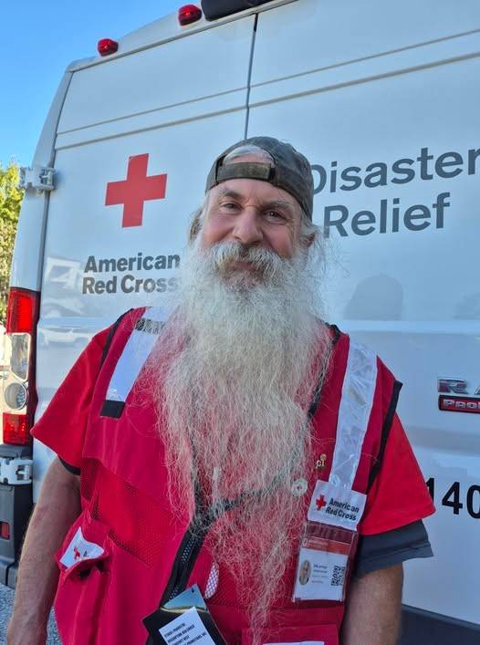 Man with beard in Red Cross vest