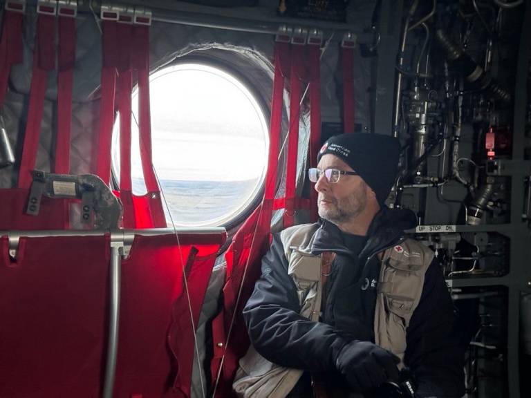 Man in Red Cross vest  aboard military plane