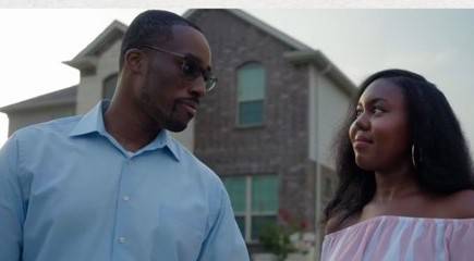 Man and woman in front of a house