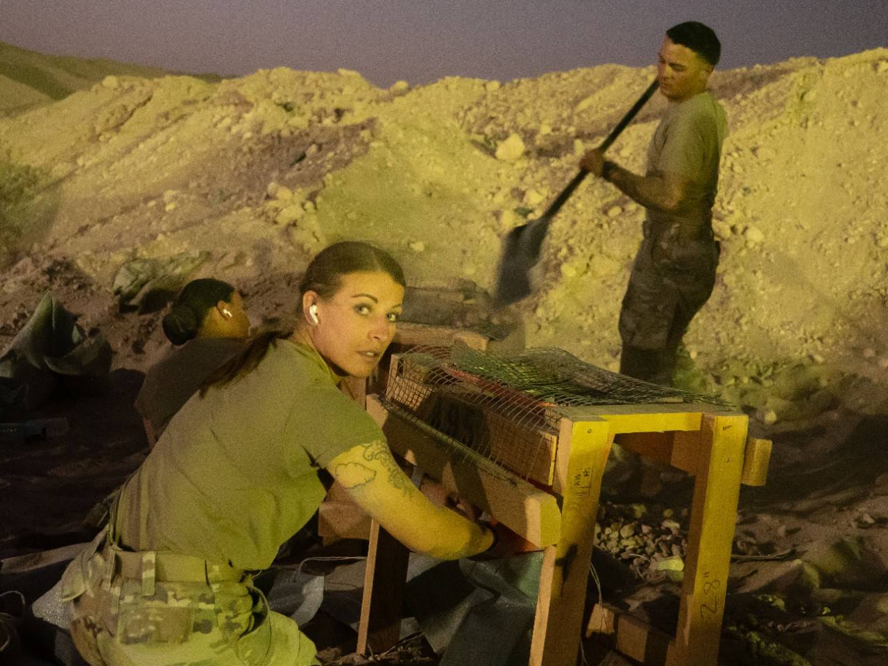 Heather Trentham and others from her unit fill sandbags at night.