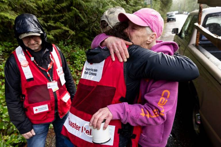 Two women hugging, one in Red Cross vest