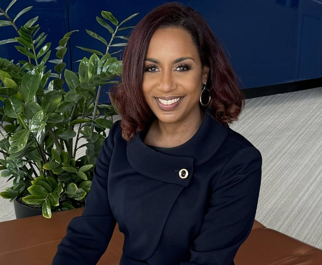 Headshot of Dr. Monique Rainford, an OB-GYN and author, smiling against a neutral background.
