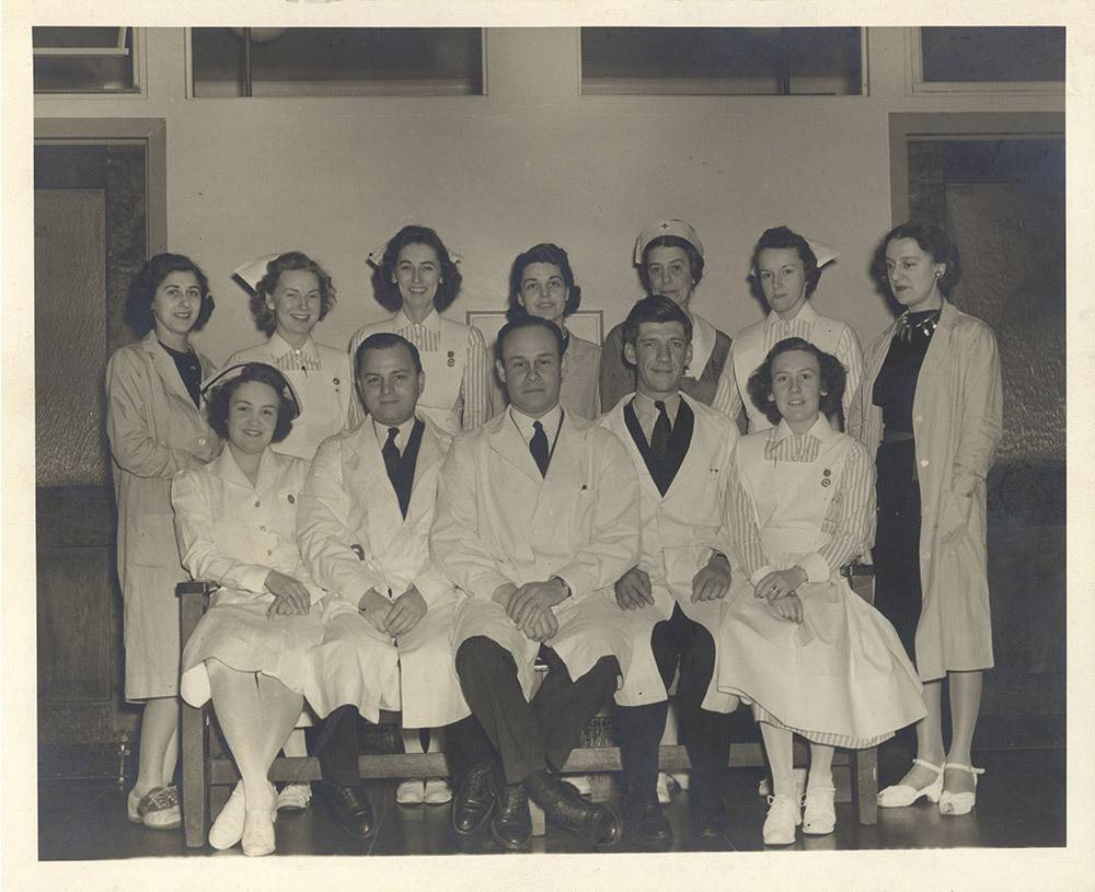 Black-and-white photograph of Dr. Charles R. Drew seated at the center of a group of Red Cross colleagues in 1941.