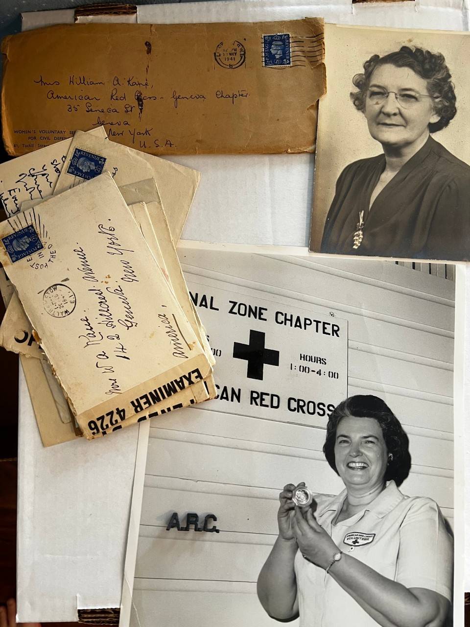 This image shows a collection of vintage American Red Cross memorabilia. It includes an old photograph of a person in glasses and dark clothing, an envelope with handwritten text addressed to someone in Georgia, and another photograph featuring a person in a Red Cross uniform holding a medal in front of a sign that reads "American Red Cross.