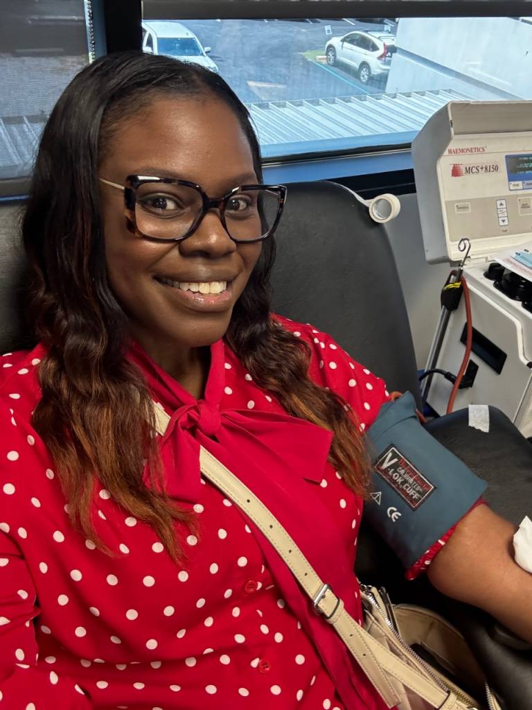A woman smiling while donating blood 