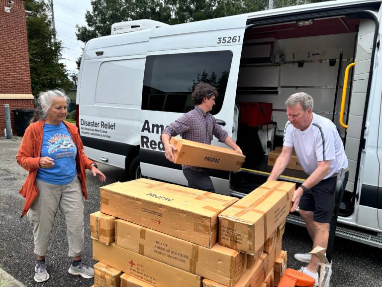 Volunteers load relief supplies into a vehicle.
