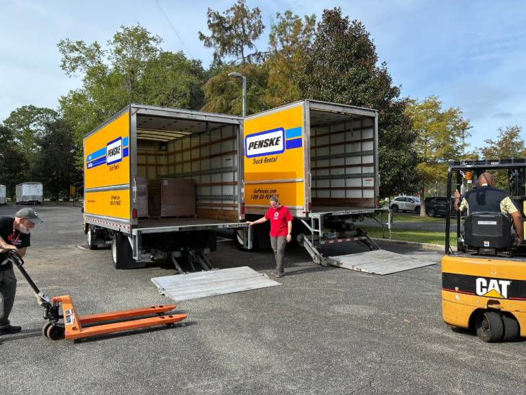 Volunteers load relief supplies into trucks.
