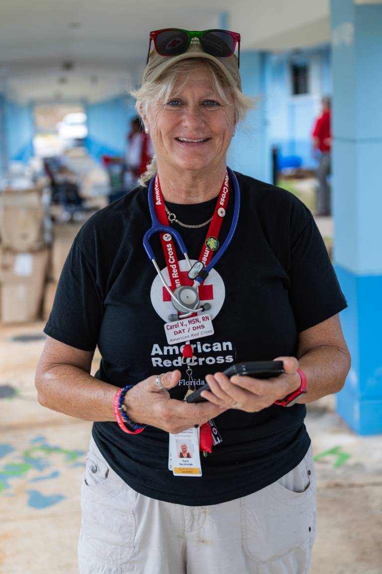 Woman in black Red Cross tee shirt with stethoscope around her neck