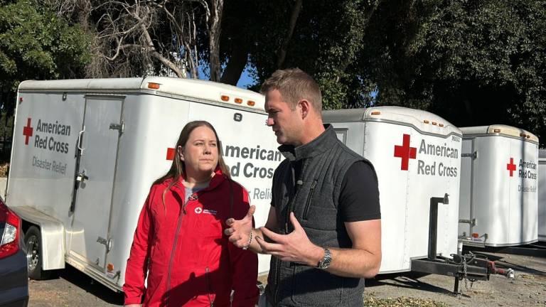 woman wearing Red Cross shirt speaking to man wearing a Red Cross shirt