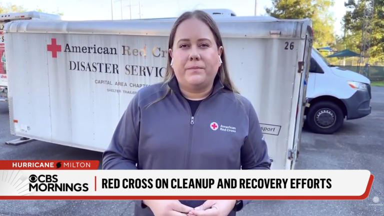 Woman in Red Cross shirt talking on news station on national TV