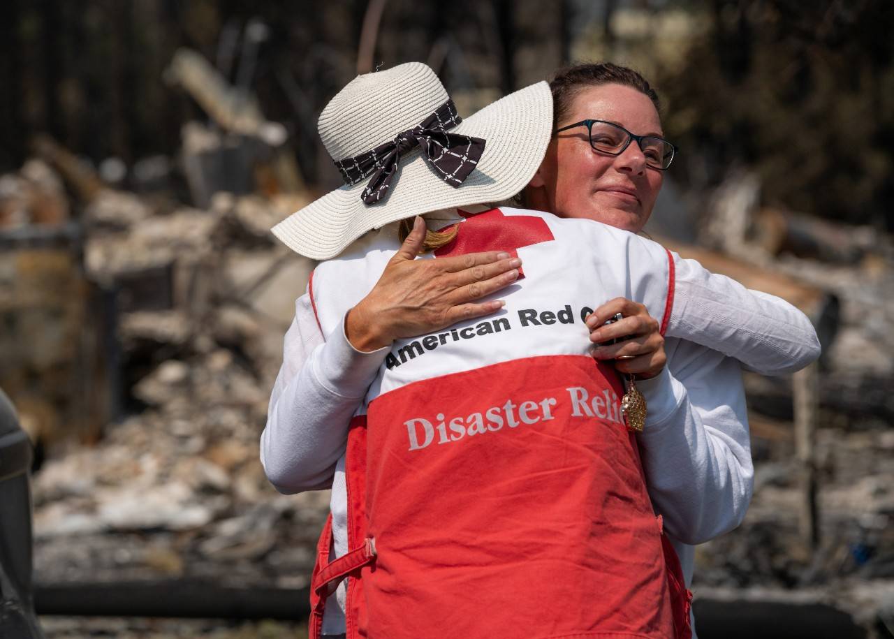 A Red Cross volunteer hugs a woman during the Western Wildfires response.