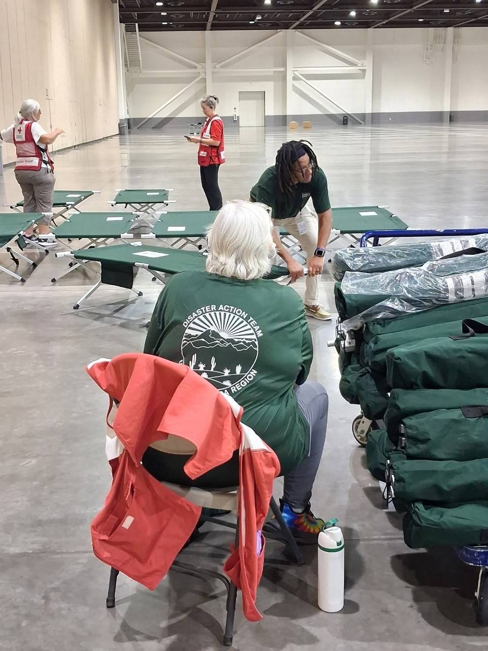 People pull out equipment from bags and set up cots.