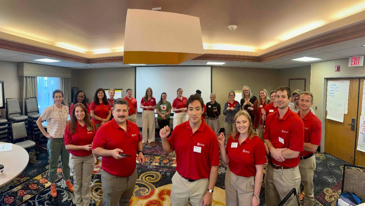 Red Cross workers gather in a room for team-building exercises
