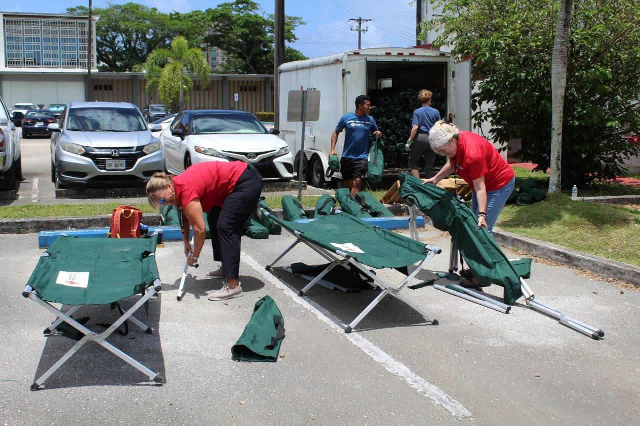 Group of people in Red Cross tee shirts clean shelter cots