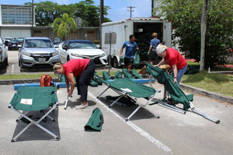Group of people in Red Cross tee shirts clean shelter cots