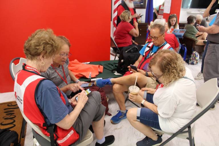 People in Red Cross tee shirts and vests gather in Guam