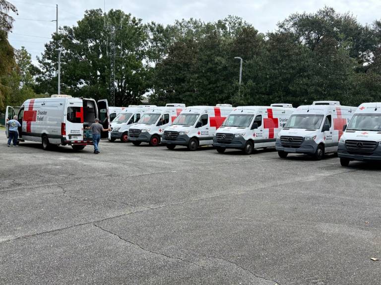 A line of Red Cross emergency vehicles parked and ready to help.