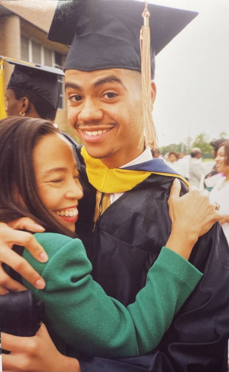  Patricia McGill wraps her son Crawford in a hug as he stands in his graduation cap and gown.