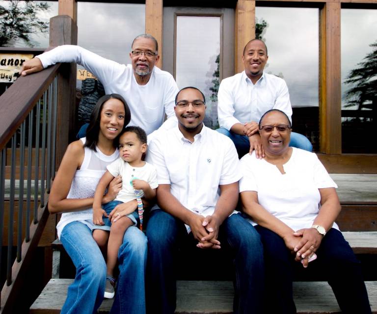 Avant with her family — her mother, father, brother, husband, and young son seated together outdoors.