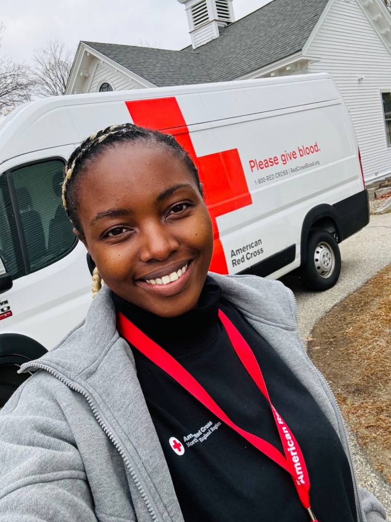 Young woman wearing Red Cross shirt and lanyard.