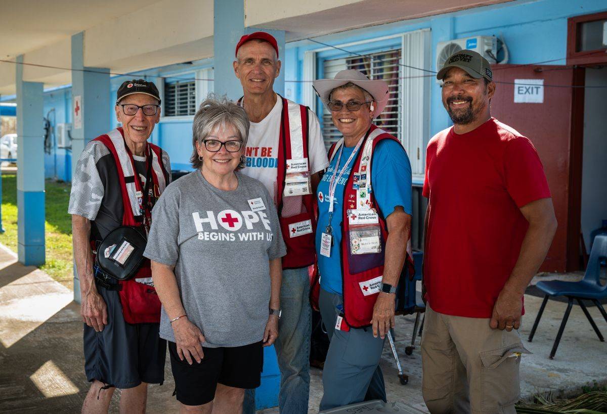 Several people in Red Cross shirts and vests stand for a photo.