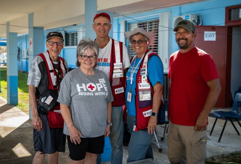 Several people in Red Cross shirts and vests stand for a photo.