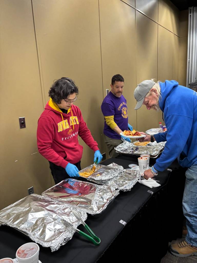 woman stands behind food-covered table