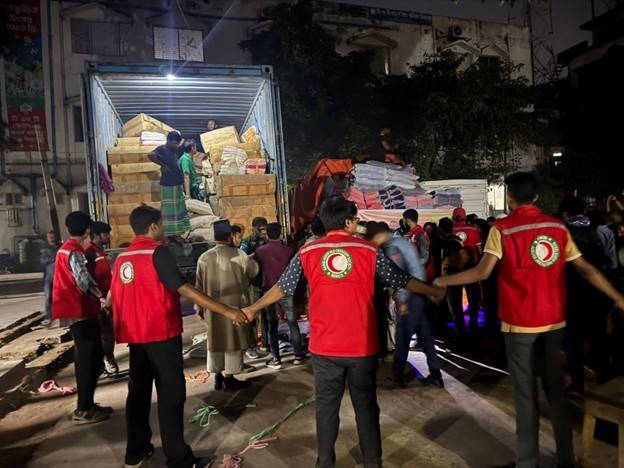 Group of Red Crescent workers join hands to direct people to relief supplies