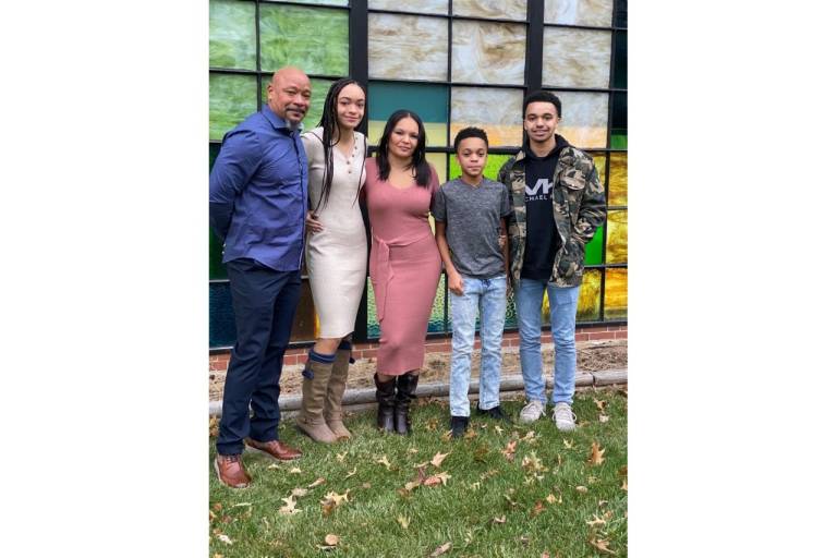 Black family of five stand together