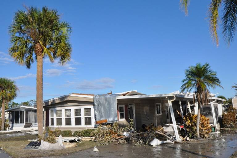 A destroyed home with major roof damage.