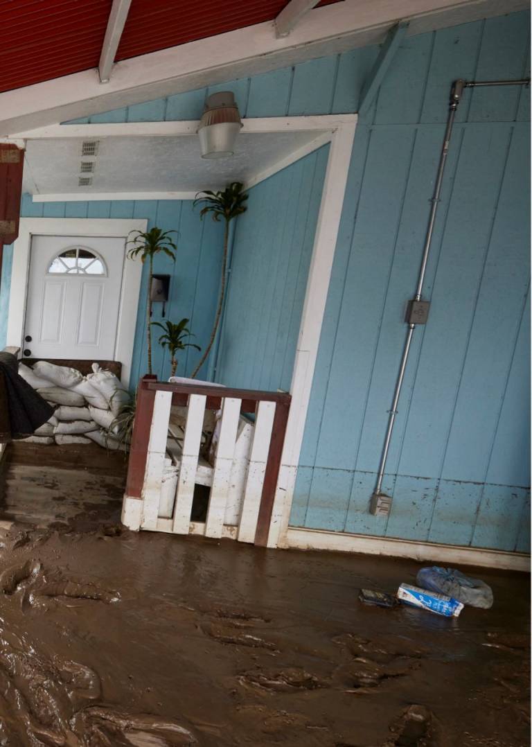 A home where flooding has subsided, but the water line can be clearly seen.