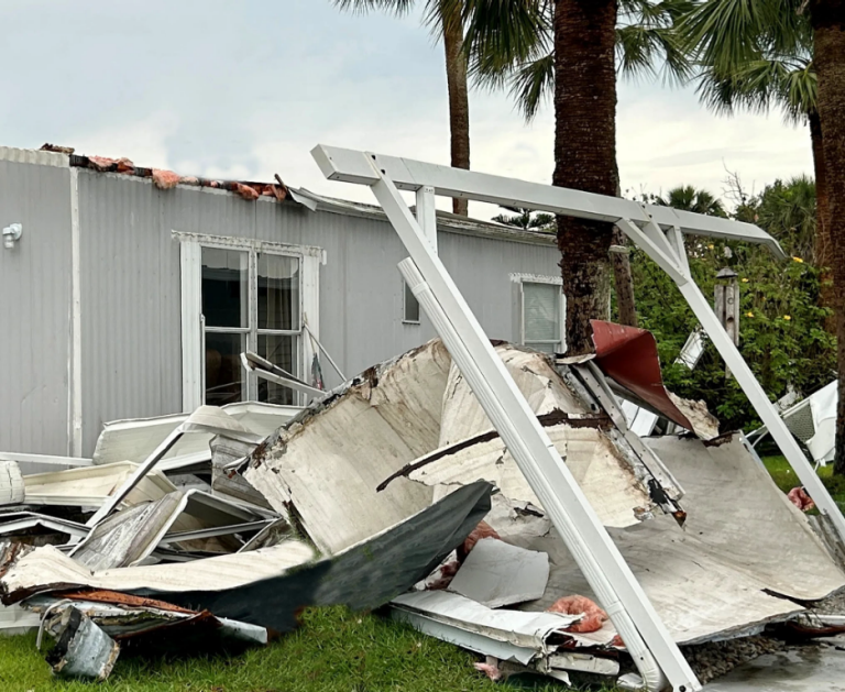 A mobile home with damage to the carport