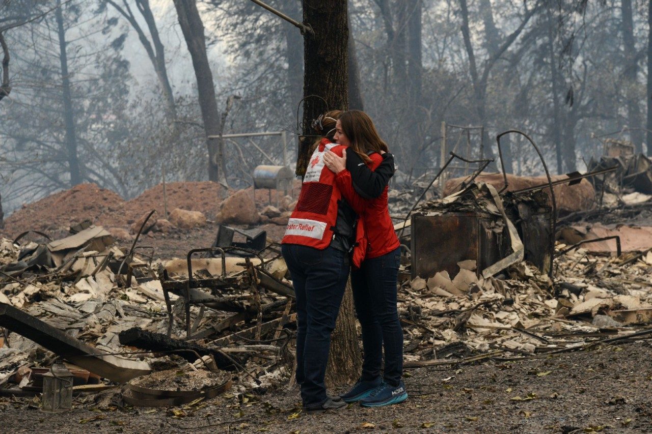 two disaster relief volunteers embracing eachother