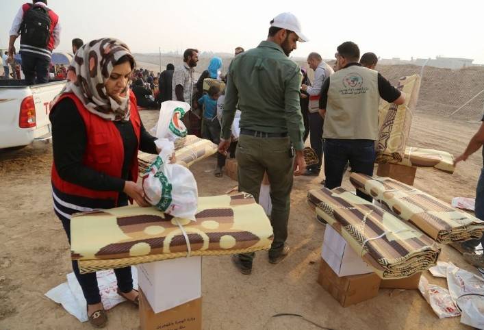 Volunteers and staff prepare relief supplies for families arriving in Khazer camp, east of Mosul.  Photo: Safin Ahmed / Iraqi Red Crescent Society