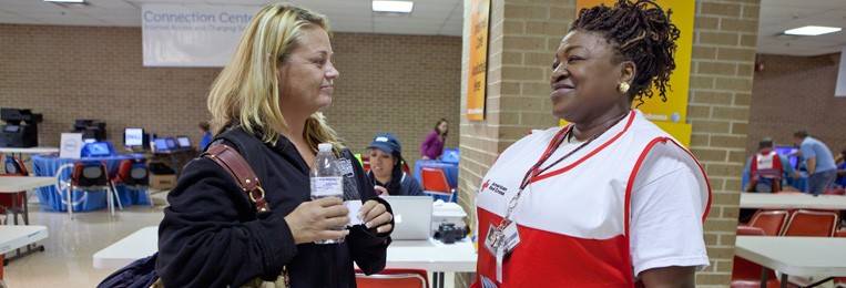 Red Cross volunteer helping lady in a shelter