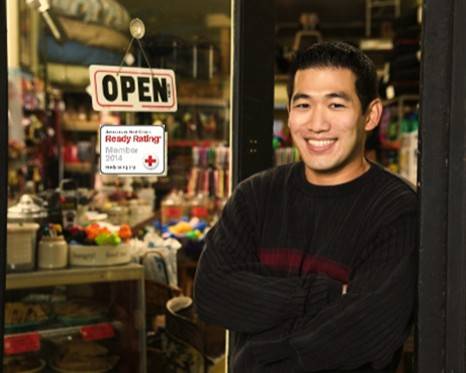 Man standing in front of a storefront with a Red Cross Ready Rating sticker on the windowpane