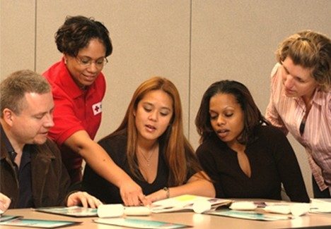 Red Cross personnel pointing to a document and explaining the Ready Rating program to participants