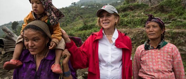 Gail McGovern and the crew trek along to see destroyed houses along the remote hills near Dunche with Red Cross staff.